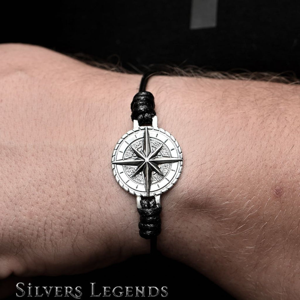 Bracelet with a compass design on a wrist, branded 'Silvers Legends'.