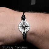 Bracelet with a compass design on a wrist, branded 'Silvers Legends'.