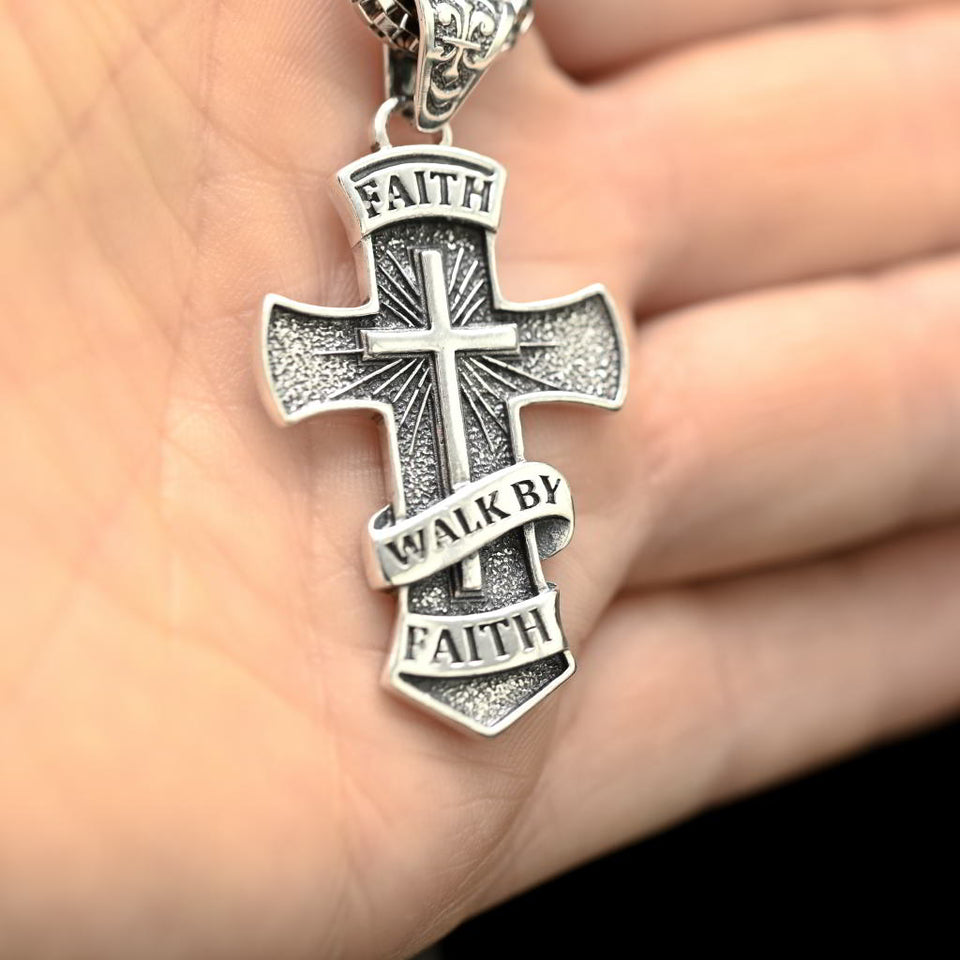 Religious silver necklace for men with cross pendant and box chain. Silver cross pendant with 'Faith Walk by Faith' text held in a hand.