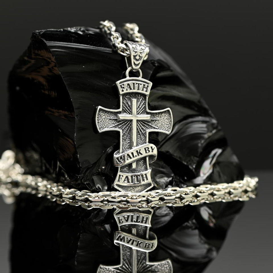 Silver cross pendant necklace with 'Faith Walk by Faith' text on a black background