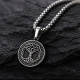 A 925 sterling silver Celtic knot tree of life pendant necklace on a dark textured rock surface.
