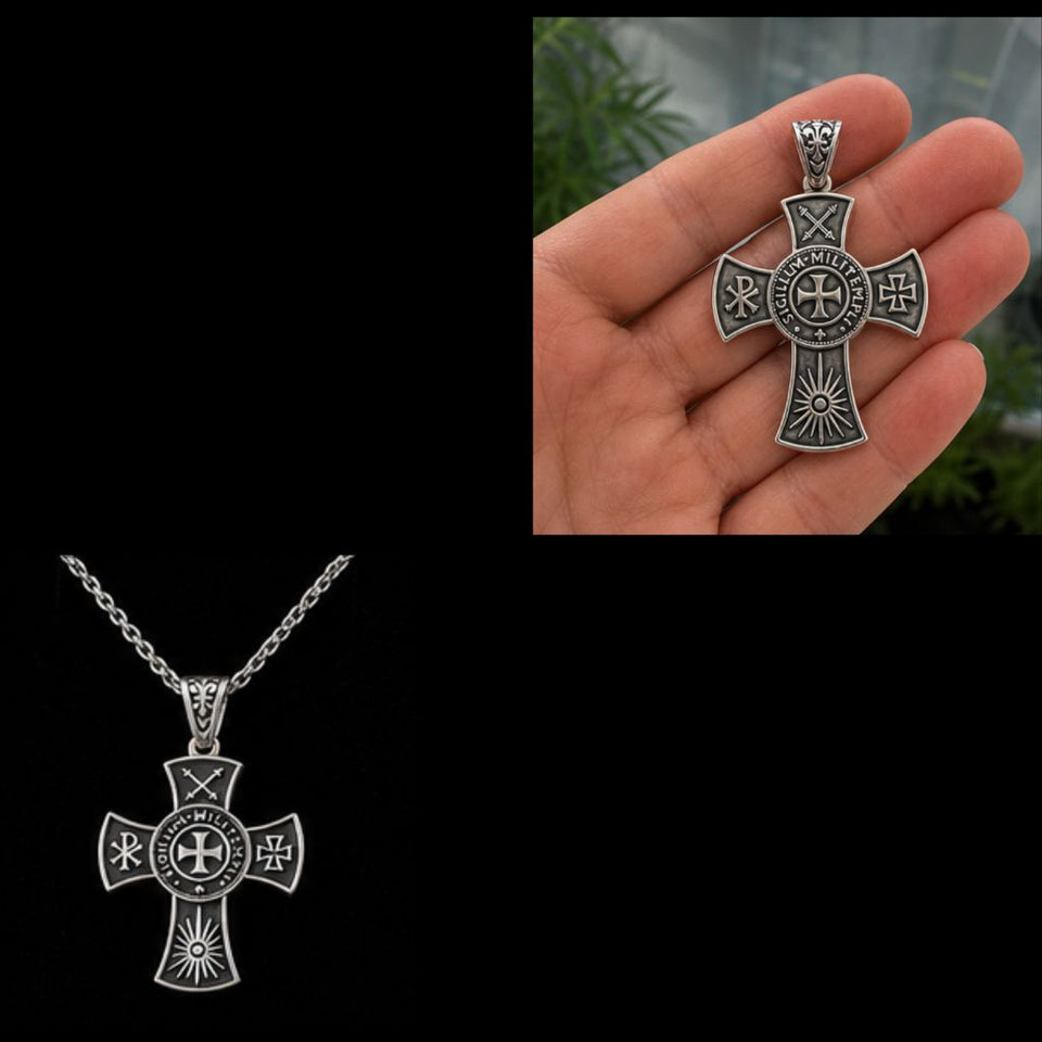 Silver cross pendant on a chain with close-up of pendant held in hand against a blurred green background.