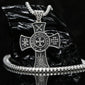 Handcrafted 925 sterling silver medieval cross necklace for men. A silver-toned metal cross pendant necklace with religious symbols and the words 'LIGHT MIGHTY CROSS' on the center, displayed on a black reflective surface with a matching chain and bracelet.