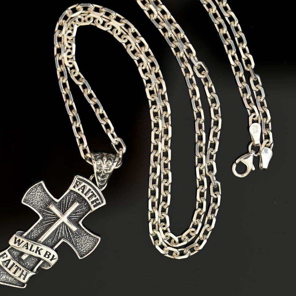 silver chain necklace with a Faith cross pendant on a black background