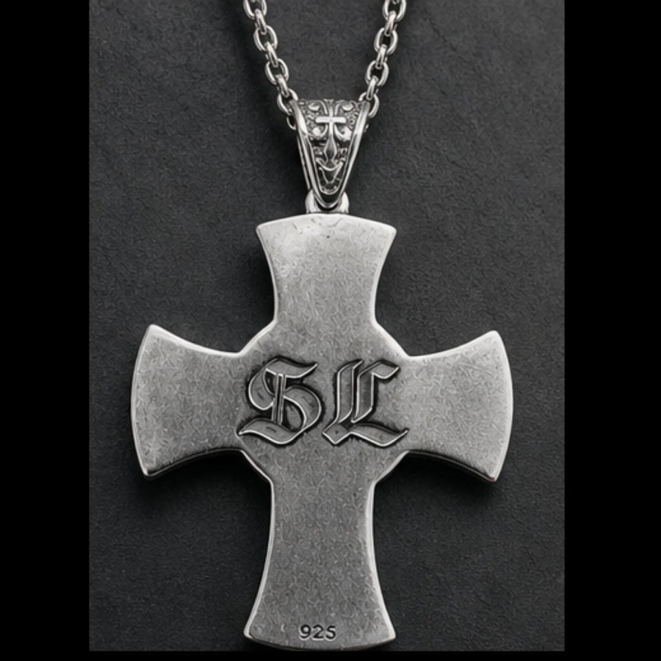 Silver cross pendant with 'SL' initials on a dark background