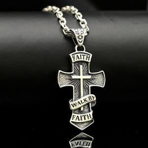 Silver cross pendant necklace with 'Faith Walk by Faith' text on a dark background
