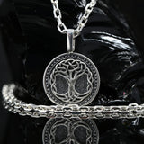 Silver Tree of Life pendant paired with 3mm sterling silver anchor chain. A 925 sterling silver tree of life pendant necklace with a matching chain and bracelet, displayed on a glossy black reflective surface.