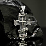 Silver cross pendant Faith with engraved text on a reflective surface