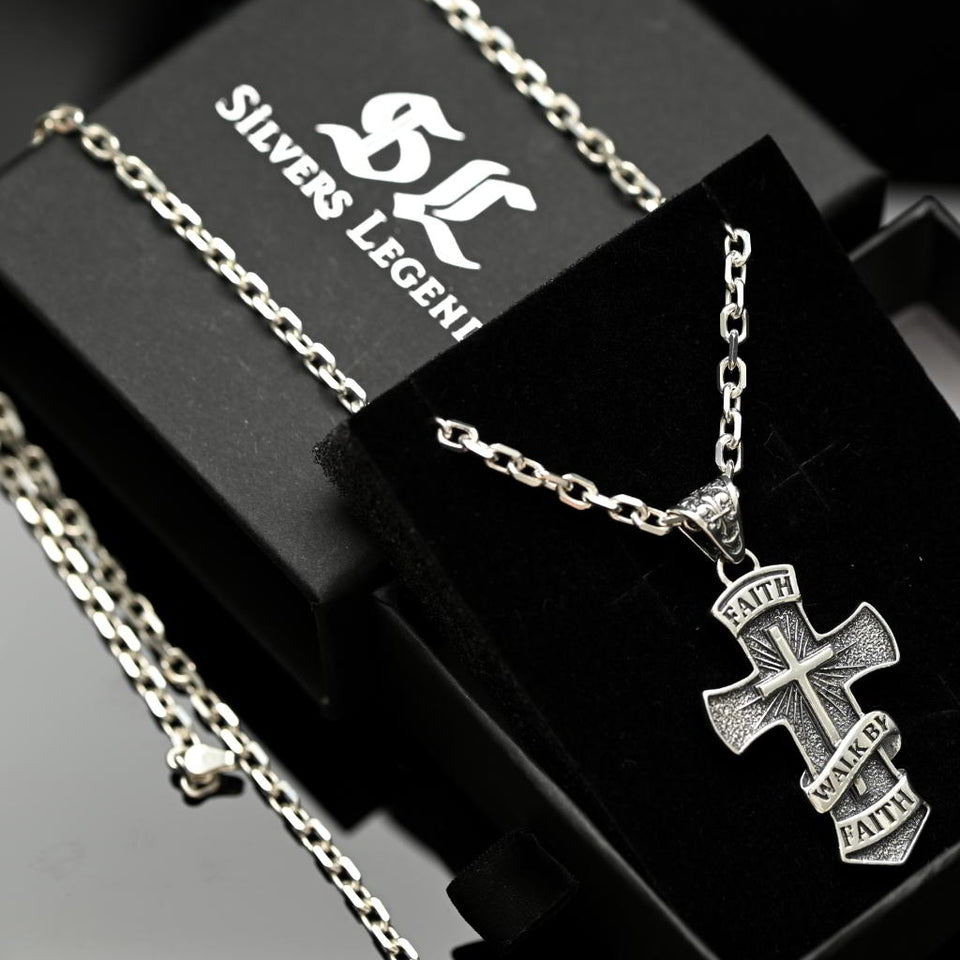 Silver cross necklace with 'Faith' engraving on a black box with 'Silvers Legend' branding.